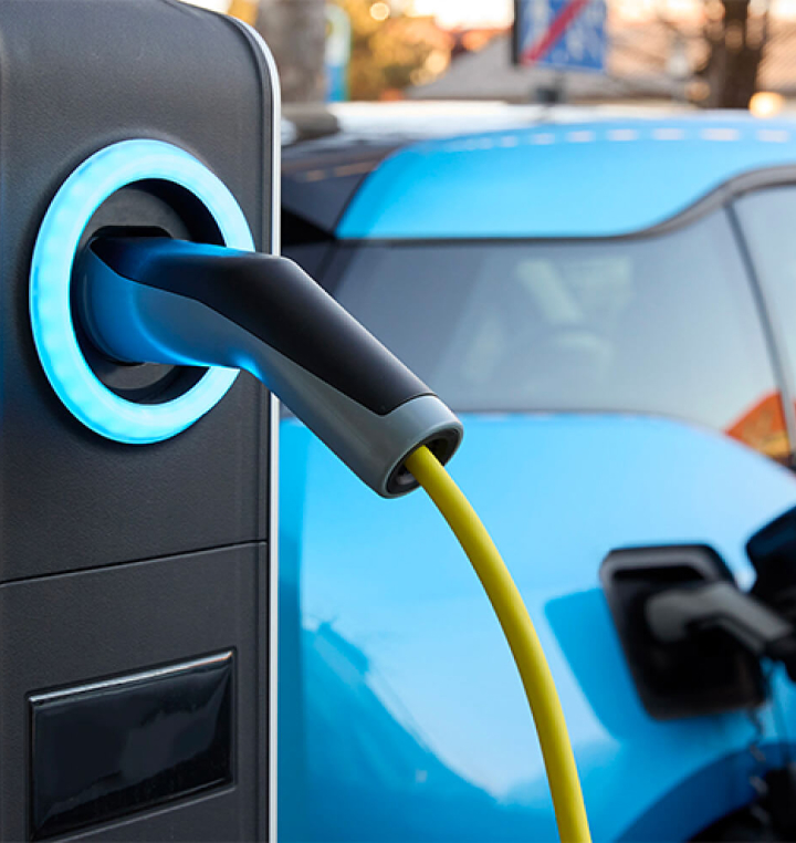 A blue electric vehicle at a charging station.